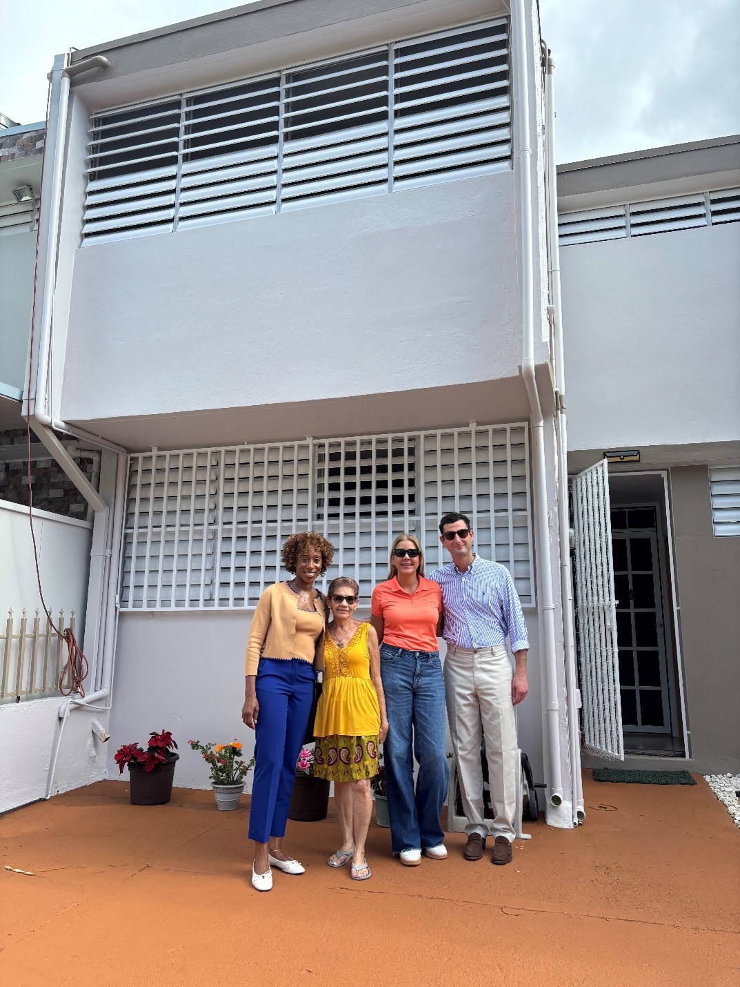 Max Epstein and Jahmila Vincent pose in front of rehabilated house with FMMM members