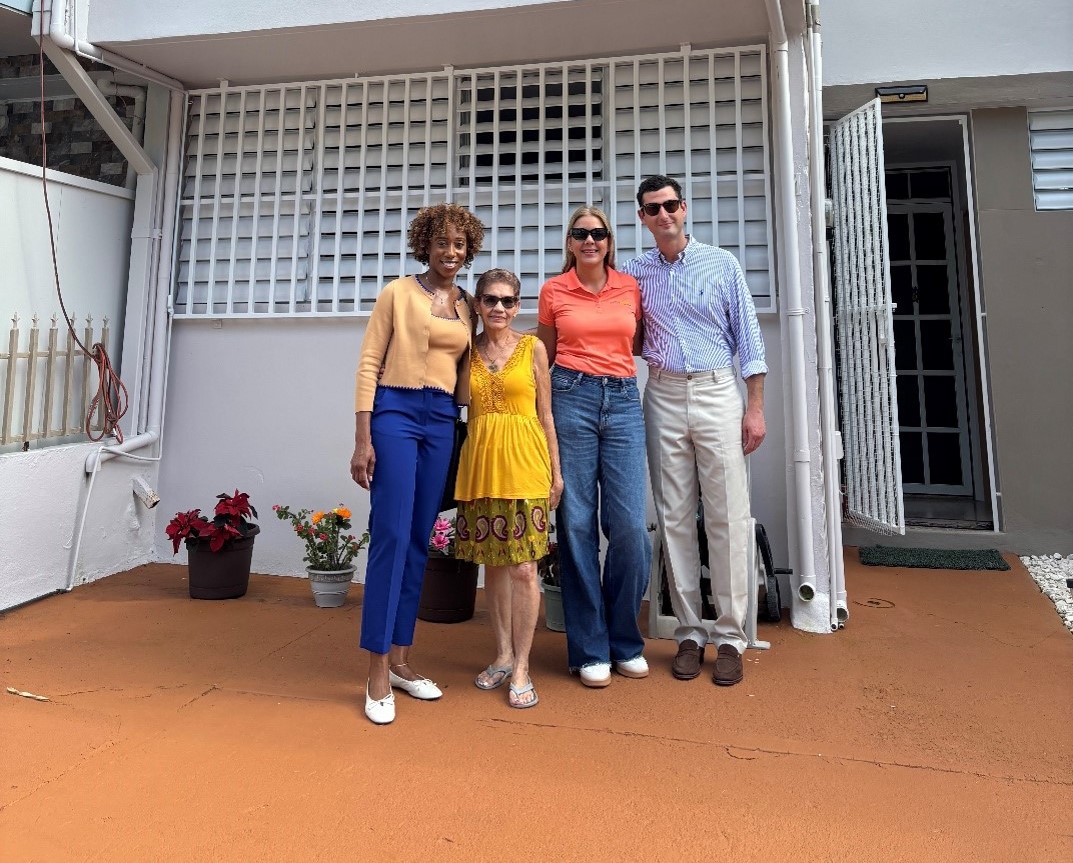Max Epstein and Jahmila Vincent pose in front of rehabilated house with FMMM members